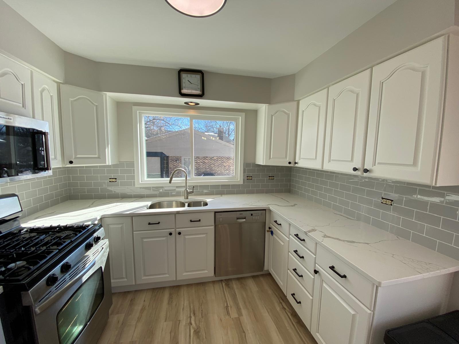 Freshly painted white kitchen cabinets with subway tile