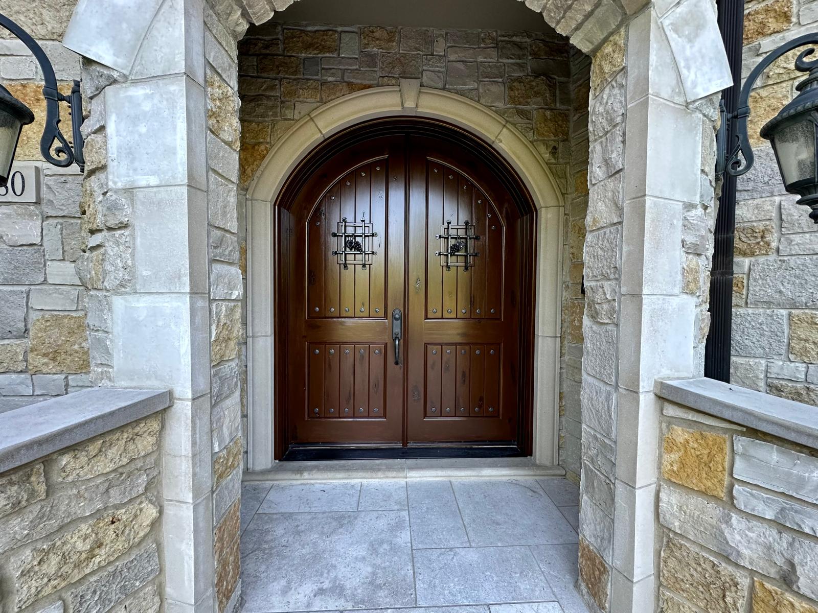 Stone archway with stained double entry door
